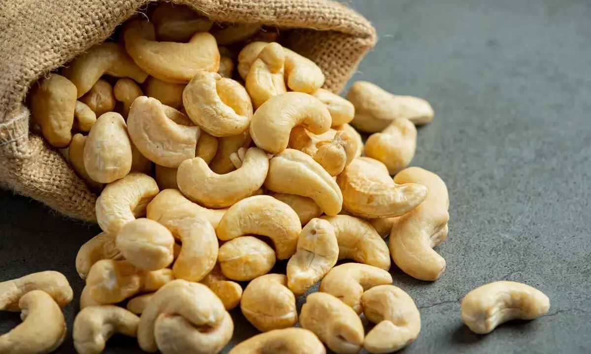 Anacardos desbordándose de un saco de arpillera, mostrando sus deliciosas propiedades nutritivas.