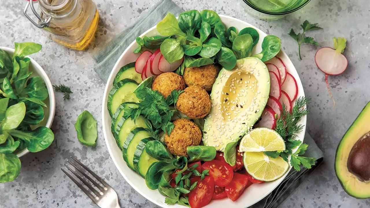 Bowl de ensalada vibrante con falafel, aguacate, pepino, tomate y rábano. Un ejemplo perfecto de una dieta flexitariana equilibrada y deliciosa.