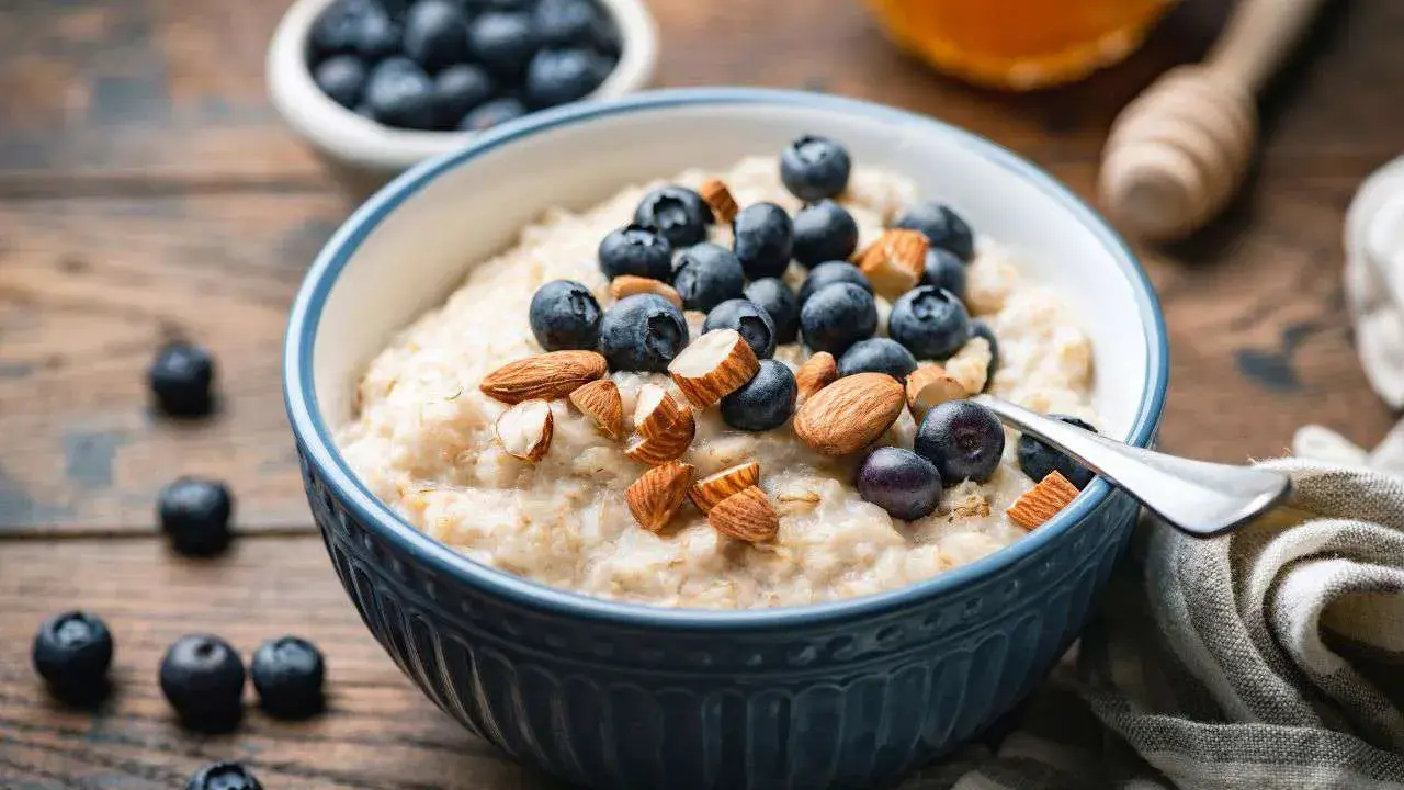 Un tazón de avena cremoso con arándanos y almendras. Una forma deliciosa de como comer avena para empezar el día.