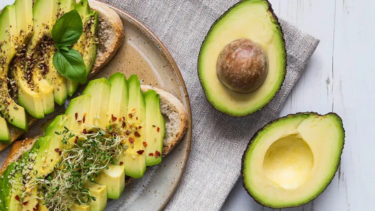 Tostadas de aguacate con brotes y especias. El aguacate, rico en grasas saludables, es un alimento nutritivo.