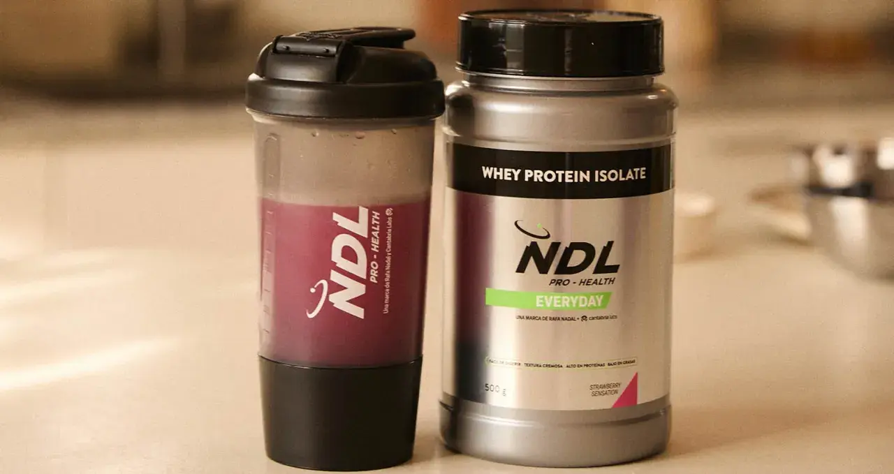 Batido de proteína NDL y su envase. ¿Cuántos scoops de proteína tomar? Elige tu sabor favorito.