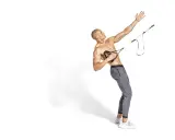 Hombre musculoso realiza ejercicio de remo TRX, con su brazo extendido hacia arriba y el otro sujetando las asas.