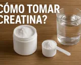 Un frasco y una cuchara con creatina en polvo, junto a un vaso de agua. ¿Cuánto tiempo se puede tomar creatina?