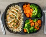 Pollo a la parrilla con arroz integral y brócoli con zanahorias. Una comida equilibrada que ayuda a entender qué es el déficit calórico.