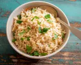 Un tazón de arroz integral esponjoso, adornado con perejil fresco, listo para ser disfrutado.