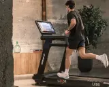 Hombre corriendo en cinta, parte de una tabla de ejercicios para perder peso.