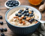 Un tazón de avena cremoso con arándanos y almendras. Una forma deliciosa de como comer avena para empezar el día.