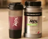 Batido de proteína NDL y su envase. ¿Cuántos scoops de proteína tomar? Elige tu sabor favorito.