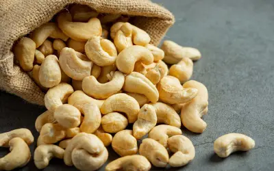 Anacardos desbordándose de un saco de arpillera, mostrando sus deliciosas propiedades nutritivas.