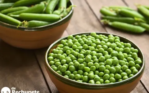 Dos cuencos llenos de guisantes frescos, uno con vainas y otro con granos sueltos. Descubre las guisantes propiedades y beneficios.