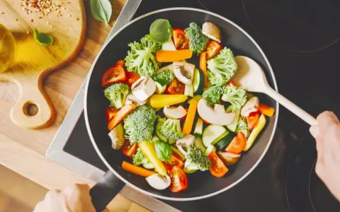 Verduras salteadas en sartén, ideal para una dieta helicobacter pylori. Brócoli, zanahoria, champiñones y tomate.