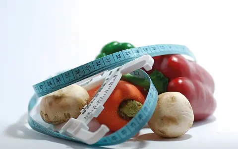Verduras frescas y cinta métrica, símbolos de dietas milagro y un estilo de vida saludable.