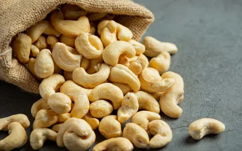 Anacardos desbordándose de un saco de arpillera, mostrando sus deliciosas propiedades nutritivas.