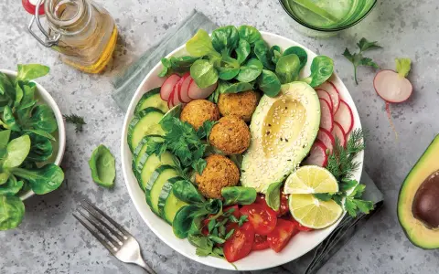 Bowl de ensalada vibrante con falafel, aguacate, pepino, tomate y rábano. Un ejemplo perfecto de una dieta flexitariana equilibrada y deliciosa.