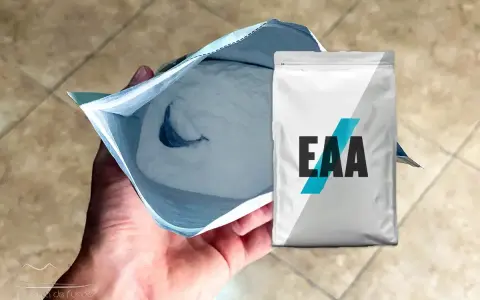 Un paquete abierto de polvo blanco, con un paquete de EAA al lado. ¿EAA para qué sirve? Para la recuperación muscular.