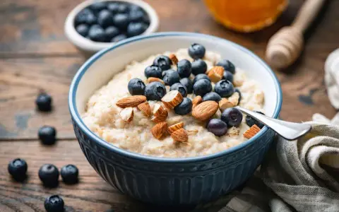 Un tazón de avena cremoso con arándanos y almendras. Una forma deliciosa de como comer avena para empezar el día.