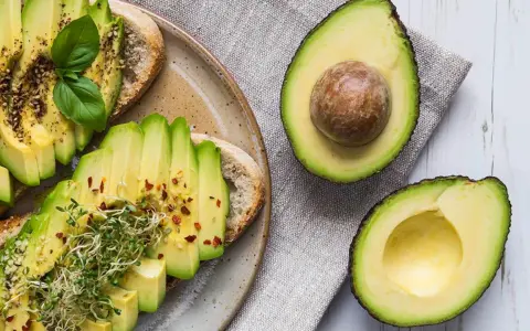 Tostadas de aguacate con brotes y especias. El aguacate, rico en grasas saludables, es un alimento nutritivo.
