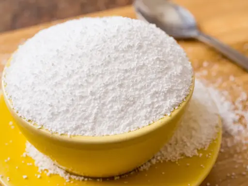 Tazón amarillo lleno de polvo blanco, posiblemente sorbitol. Cuidado con los alimentos prohibidos que lo contienen.