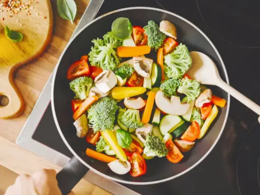 Verduras salteadas en sartén, ideal para una dieta helicobacter pylori. Brócoli, zanahoria, champiñones y tomate.