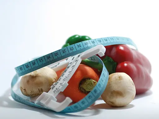 Verduras frescas y cinta métrica, símbolos de dietas milagro y un estilo de vida saludable.