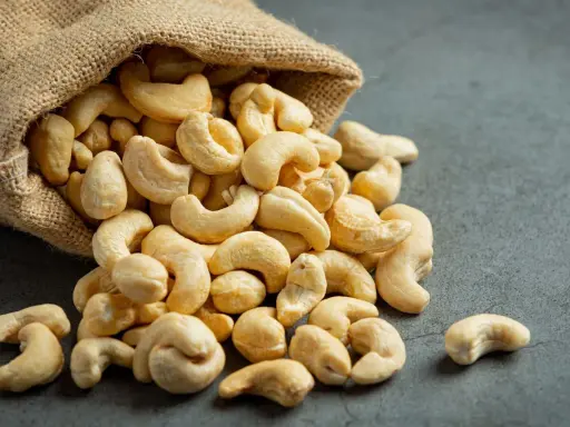 Anacardos desbordándose de un saco de arpillera, mostrando sus deliciosas propiedades nutritivas.