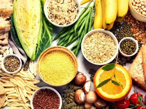Variedad de alimentos ricos en carbohidratos que engordan: arroz, avena, pasta, pan, plátanos, legumbres y verduras.