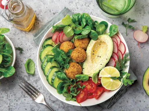 Bowl de ensalada vibrante con falafel, aguacate, pepino, tomate y rábano. Un ejemplo perfecto de una dieta flexitariana equilibrada y deliciosa.