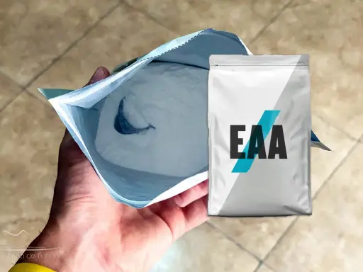 Un paquete abierto de polvo blanco, con un paquete de EAA al lado. ¿EAA para qué sirve? Para la recuperación muscular.