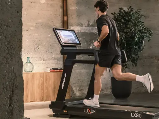 Hombre corriendo en cinta, parte de una tabla de ejercicios para perder peso.