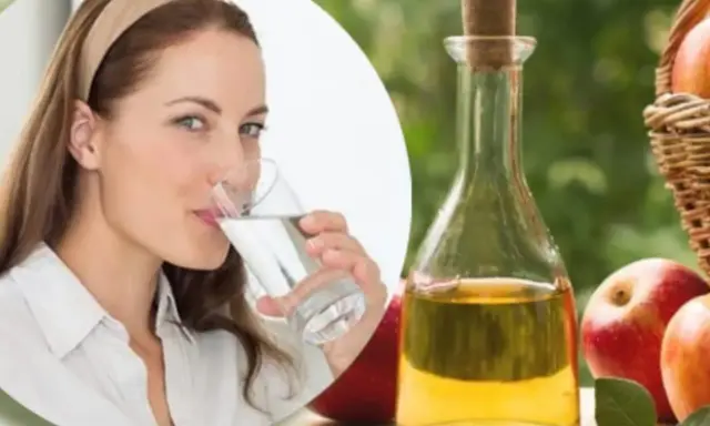 Mujer bebe agua, junto a botella de vinagre de manzana y manzanas. Una rutina saludable para tomar vinagre de manzana en ayunas.