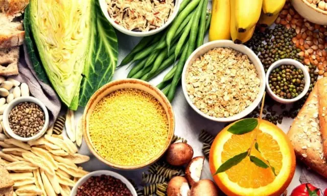 Variedad de alimentos ricos en carbohidratos que engordan: arroz, avena, pasta, pan, plátanos, legumbres y verduras.