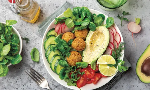 Bowl de ensalada vibrante con falafel, aguacate, pepino, tomate y rábano. Un ejemplo perfecto de una dieta flexitariana equilibrada y deliciosa.