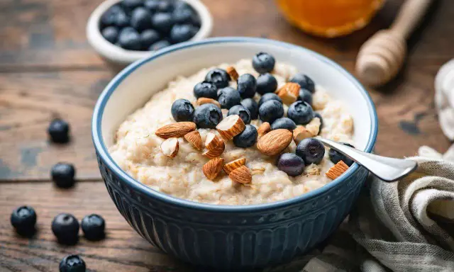 Un tazón de avena cremoso con arándanos y almendras. Una forma deliciosa de como comer avena para empezar el día.