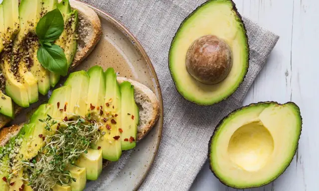 Tostadas de aguacate con brotes y especias. El aguacate, rico en grasas saludables, es un alimento nutritivo.
