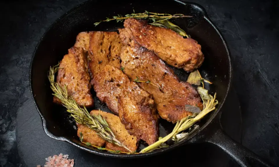 Seitan que es: trozos dorados y sabrosos de seitan cocinados en sartén con hierbas aromáticas como romero y tomillo.