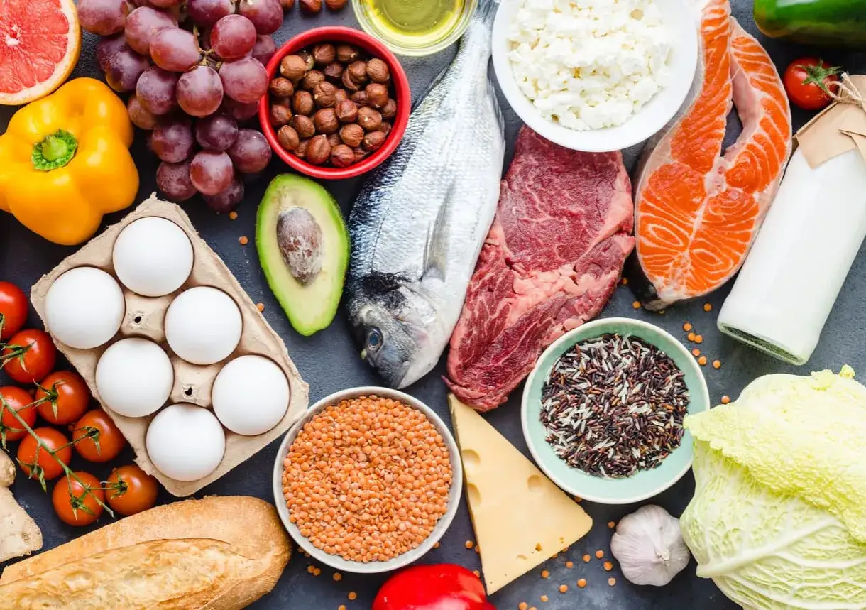 Variedad de alimentos ricos en prote&iacute;nas, esenciales para saber qu&eacute; es el amino&aacute;cido: huevos, pescado, carne, l&aacute;cteos, legumbres, frutos secos y cereales.