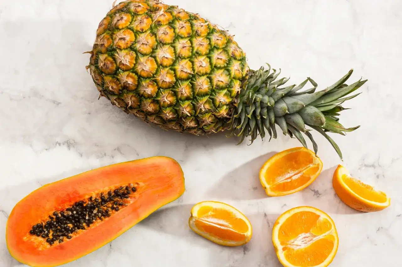 Pi&ntilde;a, papaya y naranjas, fuentes de enzimas digestivas naturales para una digesti&oacute;n saludable.