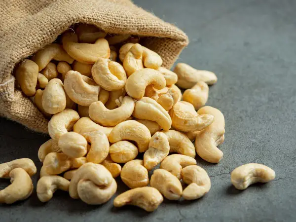 Anacardos desbordándose de un saco de arpillera, mostrando sus deliciosas propiedades nutritivas.